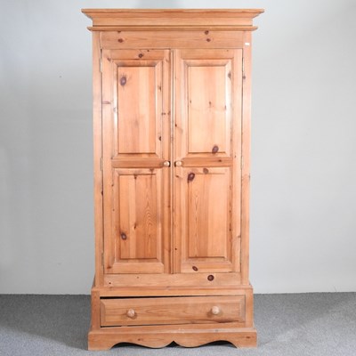 Lot 851 - A modern pine double wardrobe, with a drawer...