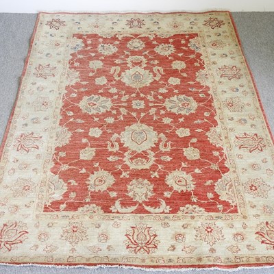 Lot 726 - A kashan carpet, with floral designs, on a red...