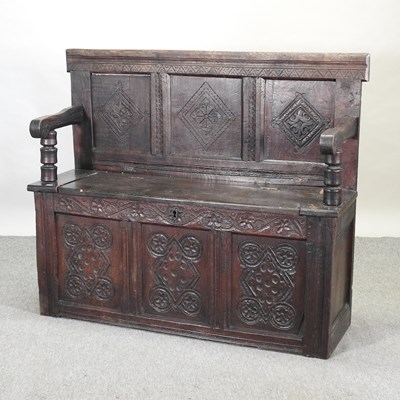 Lot 587 - A 19th century carved oak box settle