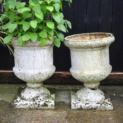 Lot 512 - A pair of composition garden urns, each on a...