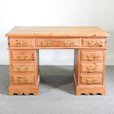 Lot 65 - A pine pedestal desk, containing nine short...