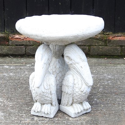 Lot 553 - A cast stone bird bath, with pelican supports,...