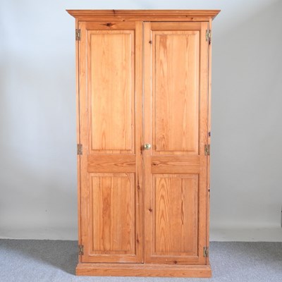 Lot 539 - A modern pine double wardrobe, enclosed by...