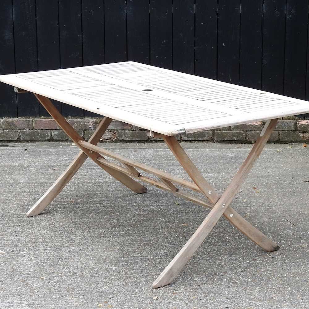 Lot 146 - A teak folding garden table, on splayed legs
