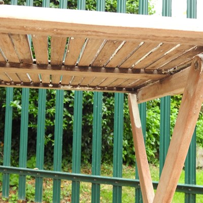 Lot 146 - A teak folding garden table, on splayed legs
