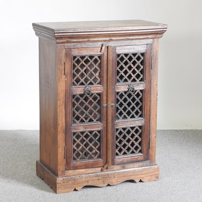 Lot 167 - An Indonesian hardwood cabinet, with grille doors