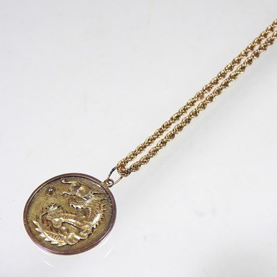 Lot 68 - A Chinese two colour gilt dragon coin pendant,...