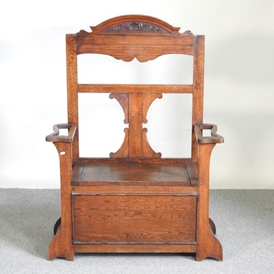 Lot 414 - An early 20th century oak box settle, with a...