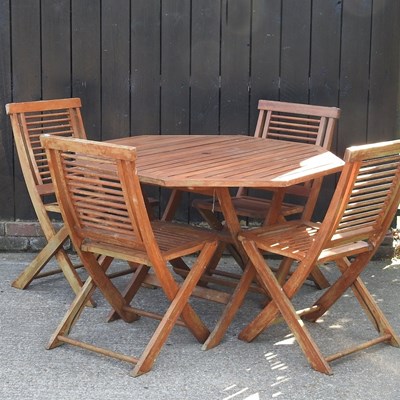 Lot 517 - A teak garden table and a set of four folding...