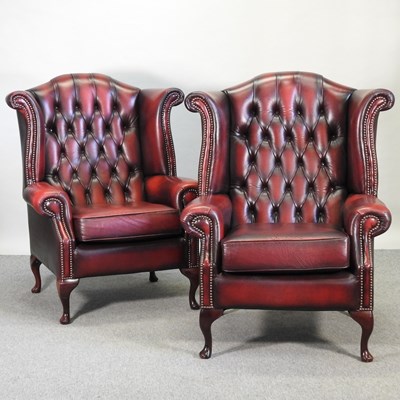 Lot 528 - A pair of red leather upholstered wing back armchairs