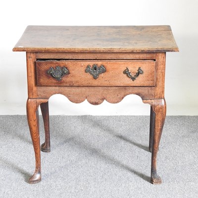 Lot 371 - An 18th century oak lowboy, with an undulating...