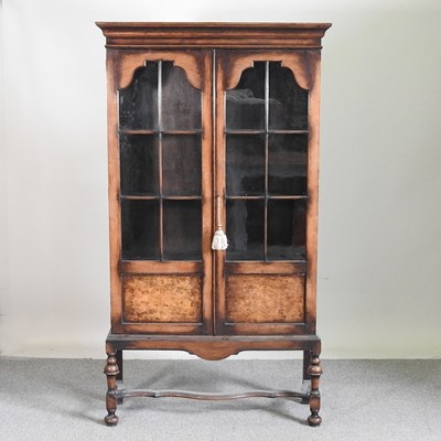 Lot 443 - A 1920's glazed bookcase, on turned legs