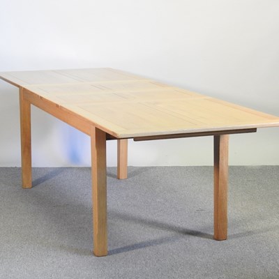 Lot 224 - A modern light oak extending dining table, on...