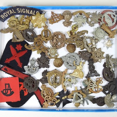 Lot 522 - A collection of cap badges and military items