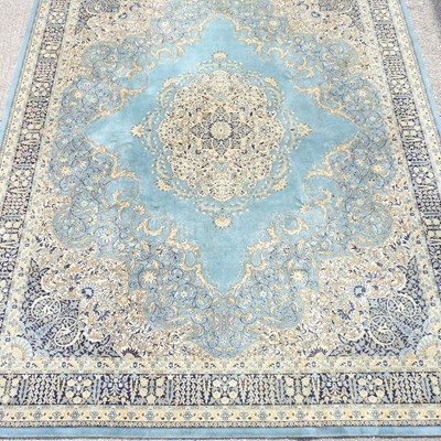 Lot 706 - A large woollen carpet on blue ground