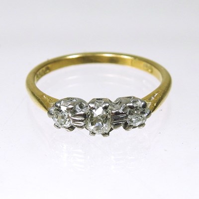 Lot 44 - An 18 carat gold three stone diamond ring,...