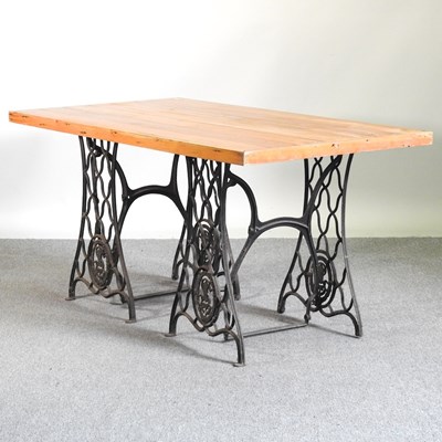 Lot 406 - A rustic pine dining table, on a painted cast...