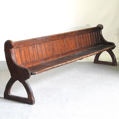 Lot 16 - A 19th century stained pine church pew, with a...