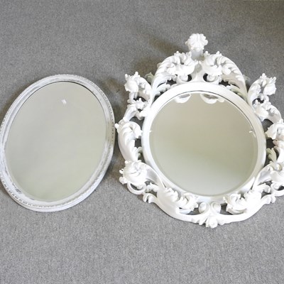 Lot 529 - An ornate white painted wall mirror, of oval...