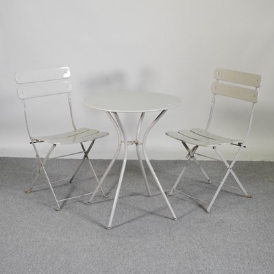 Lot 417 - A painted metal bistro table, with two folding...