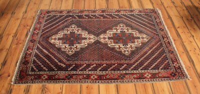 Lot 237 - A Persian Shiraz woollen rug, decorated with...