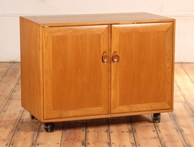 Lot 159 - An Ercol blonde elm cupboard, the two doors...