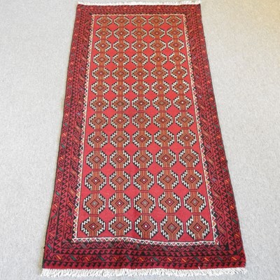 Lot 364 - A Baluch rug, with all over red medallions,...