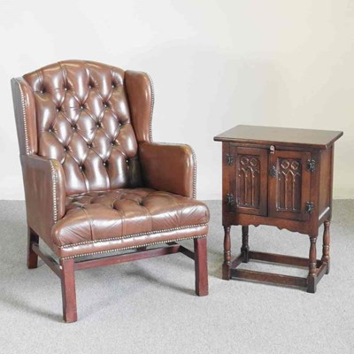 Lot 185 - A brown upholstered button back wing armchair,...