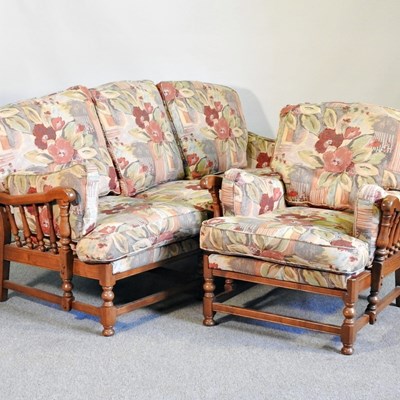 Lot 523 - An Ercol elm sofa, with floral cushions,...