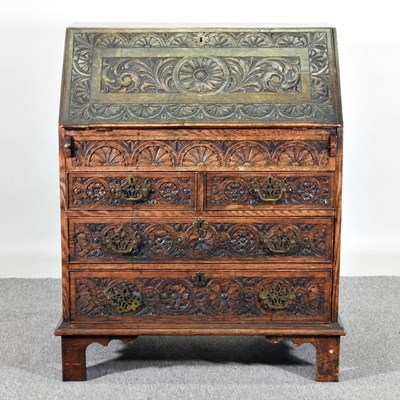 Lot 528 - A 19th century heavily carved oak bureau, on...