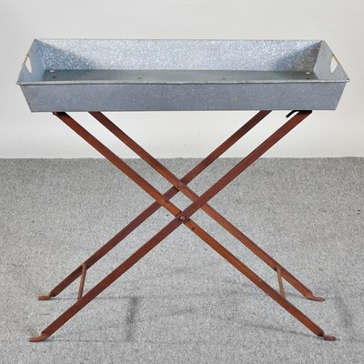 Lot 421 - A galvanised tray, on a folding iron stand