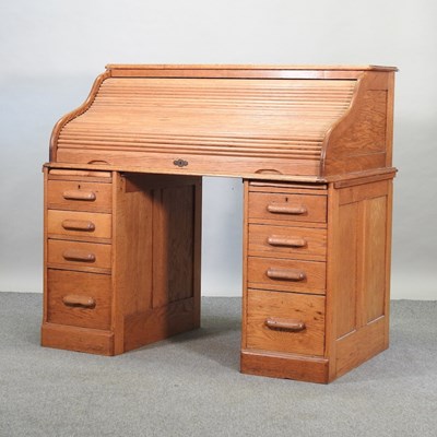 Lot 735 - An early 20th century light oak roll top desk