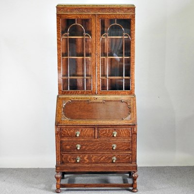 Lot 248 - A 1920's carved oak bureau bookcase, on turned...