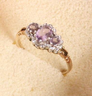 Lot 368 - A 9 carat gold three-stone amethyst dress ring,...