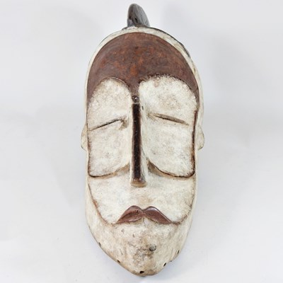 Lot 101 - A West African carved wooden and painted mask,...