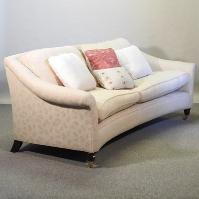 Lot 511 - A modern cream upholstered curved three seat sofa