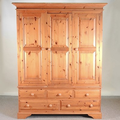 Lot 297 - A modern pine triple wardrobe, with drawers below