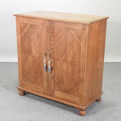 Lot 529 - A 1920's light oak cabinet