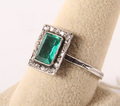 Lot 116 - A platinum, emerald and diamond cluster ring,...