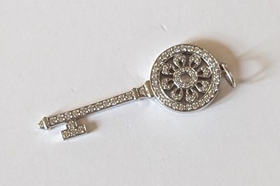 Lot 119 - An 18ct white gold Tiffany diamond key pendant,...