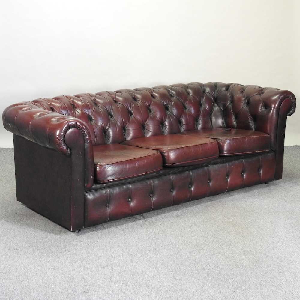 Lot 582 - A red upholstered chesterfield sofa