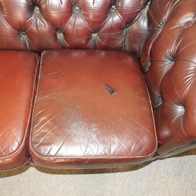 Lot 582 - A red upholstered chesterfield sofa