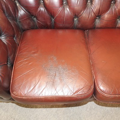 Lot 582 - A red upholstered chesterfield sofa