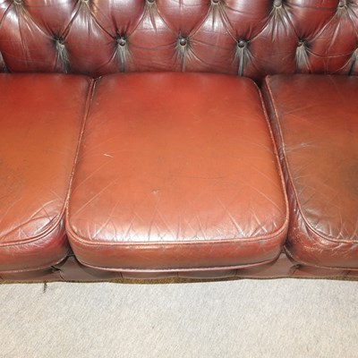 Lot 582 - A red upholstered chesterfield sofa