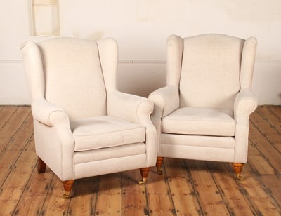 Lot 419 - A pair of pale upholstered wingback Highland...