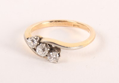 Lot 81 - An 18ct gold three-stone diamond crossover...