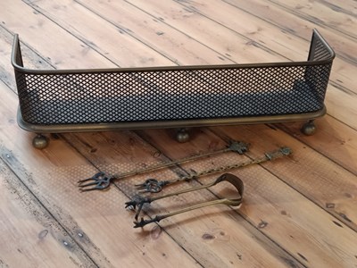 Lot 562 - A brass fire fender, 87cm, with brass firetools