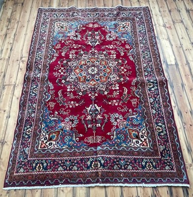 Lot 397 - A Persian Meshed carpet, having a red ground,...