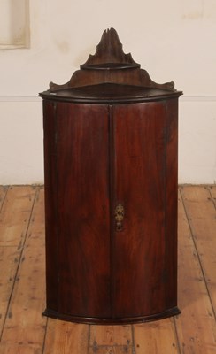 Lot 411 - A Georgian mahogany bow fronted corner cabinet,...