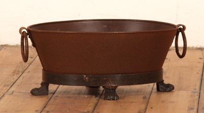 Lot 460 - A rusted iron planter, of oval shape, on paw...